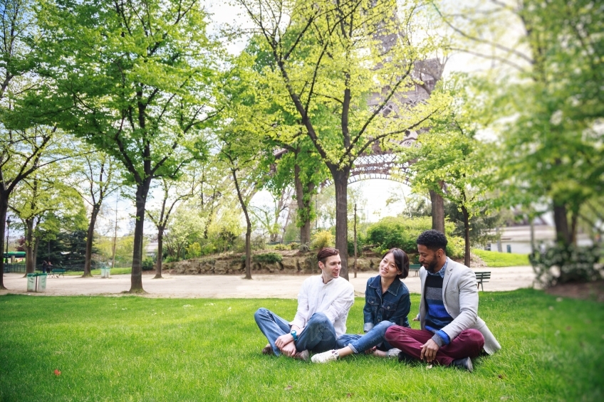 Drei Freunde sitzen im Gras vor dem Eiffelturm 20160426