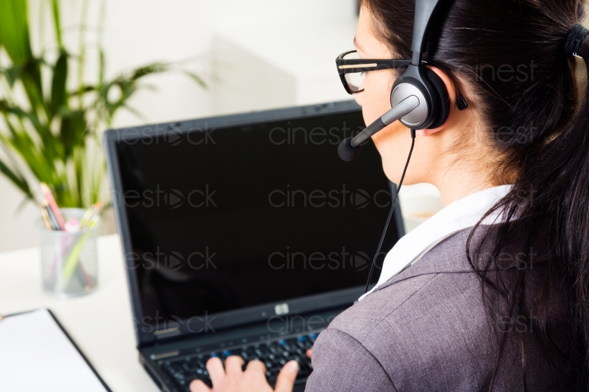Frau mit Headset am Laptop 20130216-0487