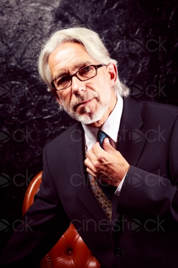 Älterer Herr im Anzug richtet Krawatte 20140722-0029