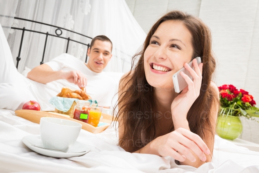 Mann Frühstückt im Bett und Frau telefoniert 20121130