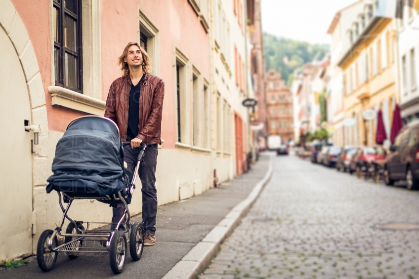 Mann geht mit Baby im Kinderwagen spazieren 20160810