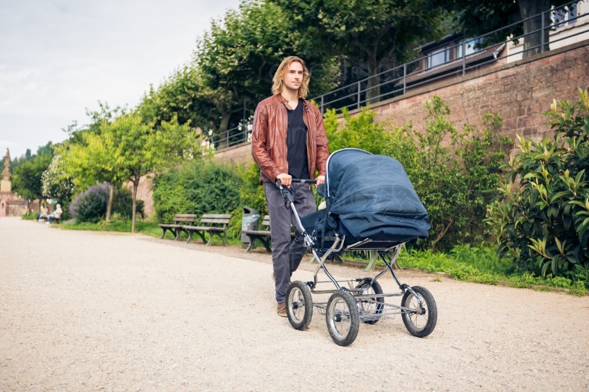 Mann geht mit Kind im Kinderwagen spazieren 20160810