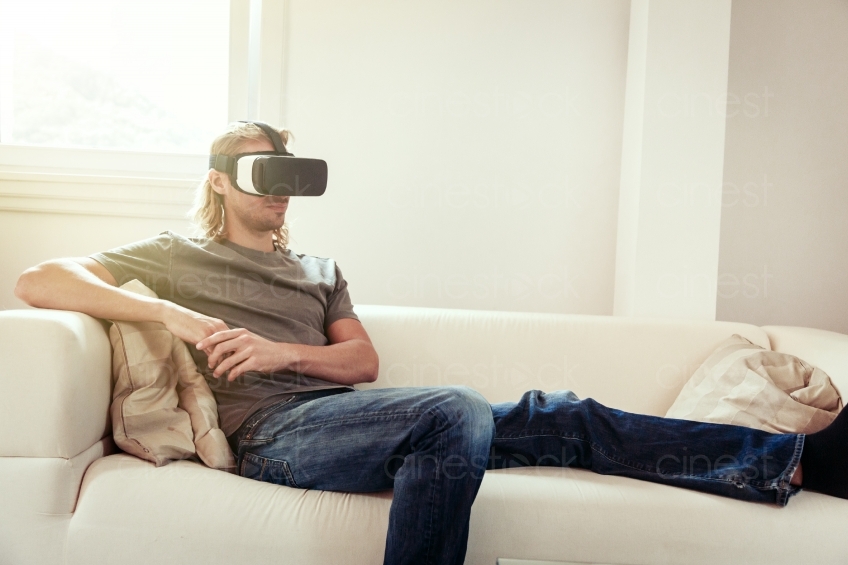 Mann sitzt mit VR-Brille auf dem Sofa 20160810