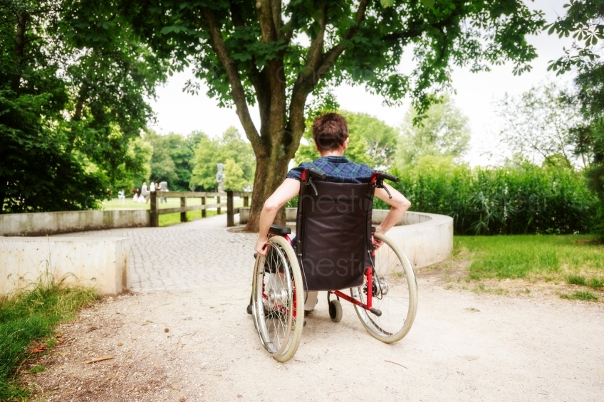 Rückenansicht von Rollstuhlfahrerin in Park 20160725-0267